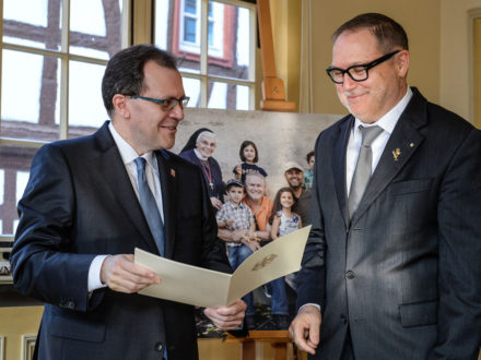 Staatssekretär Thomas Metz übergibt das Bundesverdienstkreuz an den Strahlemann-Stiftungsgründer Franz-Josef Fischer